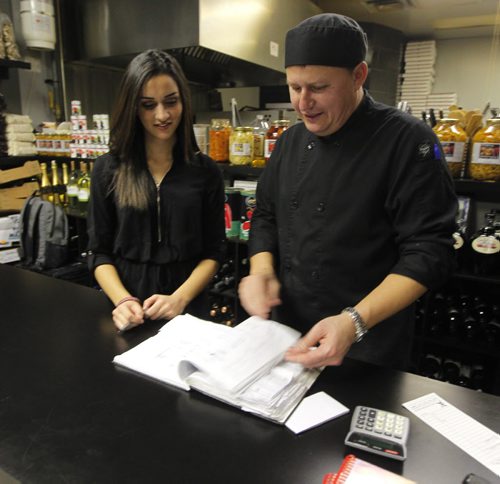 THIS CITY - Santa Ana Pizzeria & Bistro. Owner Darek Wozny (r) goes over the reservation list with employee Talia Gowdar (l).  BORIS MINKEVICH / WINNIPEG FREE PRESS  NOV 25, 2015