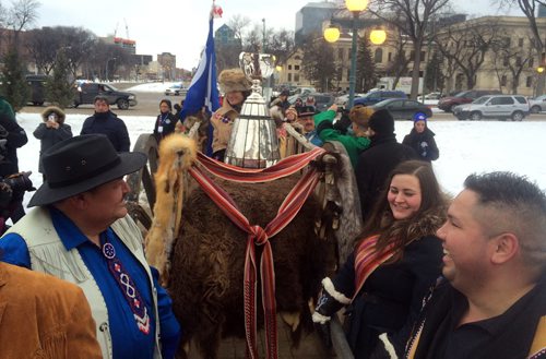 Brayden Anderson (centre behind cup) carries the Grey Cup to the Manitoba Legislative Building on a Red River Cart for the kickoff to Grey Cup festivities in Winnipeg. BORIS MINKEVICH / WINNIPEG FREE PRESS NOV 25, 2015
