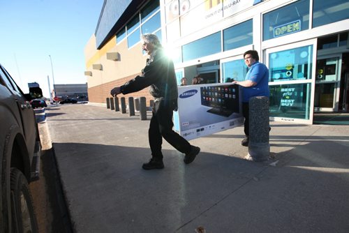 John Boechers loads up a 55 inch Samsung TV with the help of a Best Buy attendant that he just purchased at Best Buy Polo Park on Friday morning.  He drove in from Laurier Manitoba to get this deal which was about 15% off the normal price.   Standup pic Nov 27, 2015 Ruth Bonneville / Winnipeg Free Press