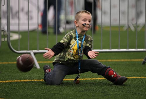 Five-year-old Zak Addison just misses catching a football while running through an obstacle course while playing in the Macdon fan experience and family zone  at the Health and Recplex at the University of Winnipeg Saturday, part of the many Grey Cup festivities in downtown Wpg. this weekend.  Nov 28, 2015 Ruth Bonneville / Winnipeg Free Press