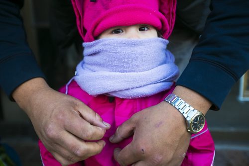 Feliksa Green, 2, gets bundled up by her dad before the Santa Claus/Grey Cup parade on Portage Avenue in Winnipeg on Saturday, Nov. 28, 2015.   (Mikaela MacKenzie/Winnipeg Free Press)