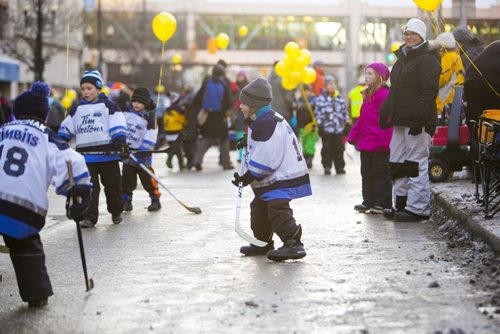 Kids pass the time by playing street hockey before the Santa Claus/Grey Cup parade on Portage Avenue in Winnipeg on Saturday, Nov. 28, 2015.   (Mikaela MacKenzie/Winnipeg Free Press)