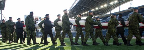 Around 150 members of Canada's military prepare the large Canadian flag before the start of the Grey Cup championship game between the Ottawa Redblacks and the Edmonton Eskimos in Winnipeg, November 29, 2015. 151129 - Sunday, November 29, 2015 -  MIKE DEAL / WINNIPEG FREE PRESS