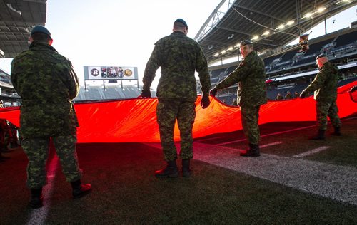 Around 150 members of Canada's military prepare the large Canadian flag before the start of the Grey Cup championship game between the Ottawa Redblacks and the Edmonton Eskimos in Winnipeg, November 29, 2015. 151129 - Sunday, November 29, 2015 -  MIKE DEAL / WINNIPEG FREE PRESS