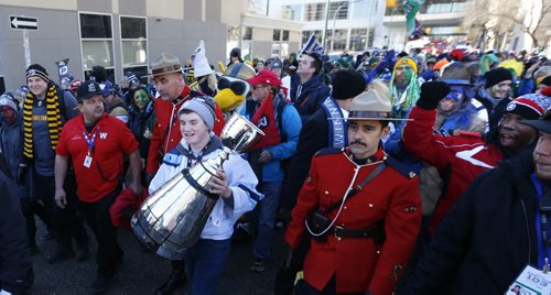 Liam Howe from Toronto takes his turn carrying the Grey Cup on the Fan March to The Forks.This is his fourth March he has had the opportunity to carry the trophy.   Geoff Kirbyson  story.Wayne Glowacki / Winnipeg Free Press Nov. 29    2015