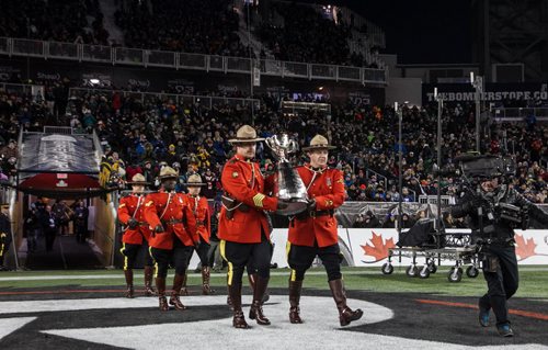 The Grey Cup is guarded by RCMP officers is brought onto the field during the pre-game show at the Grey Cup championship game against the Edmonton Eskimos and the Ottawa Redblacks in Winnipeg, November 29, 2015. 151129 - Sunday, November 29, 2015 -  MIKE DEAL / WINNIPEG FREE PRESS