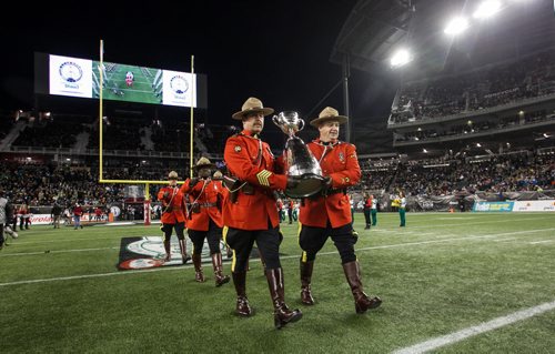 The Grey Cup is guarded by RCMP officers is brought onto the field during the pre-game show at the Grey Cup championship game against the Edmonton Eskimos and the Ottawa Redblacks in Winnipeg, November 29, 2015. 151129 - Sunday, November 29, 2015 -  MIKE DEAL / WINNIPEG FREE PRESS