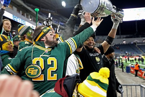 Edmonton Eskimo fans reach to touch the cup as team member bring it into the stands while  celebrating their teams win at the 103rd  Grey Cup against  Ottawa Redblacks  at Investors Group Stadium in Winnipeg on Sunday, Nov. 29, 2015.  Nov 29, 2015 Ruth Bonneville / Winnipeg Free Press