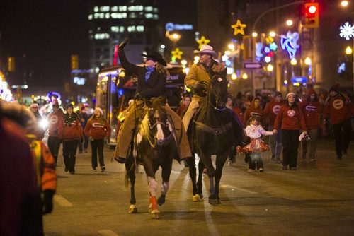 Dorie Kell (left) rides down Portage with the Asham Stompers at the Santa Claus/Grey Cup parade in Winnipeg on Saturday, Nov. 28, 2015.   (Mikaela MacKenzie/Winnipeg Free Press)