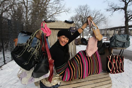 Shannon Jackson sits in the giant chair next in Assiniboine Park with a collection of purses she has been given for the  Pursue the Purse drive,  for women's shelters happening this month with one of the sponsors being the Assiniboine Park.   Dec 02, 2015 Ruth Bonneville / Winnipeg Free Press