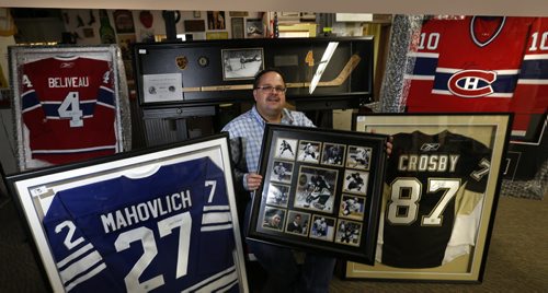 Jason Kaye, Manager and part owner of Kaye's Auction holds a frame with Sidney Crosby photographs surrounded by signed jerseys of Jean Béliveau, Frank Mahovlich, Sidney Crosby and Guy Lafleur. Also in back is a framed Bobby Orr signed replica hockey stick and the famous flying Orr photograph taken after scoring the Stanley Cup winning goal in 1970. Kaye's is auctioning off a bunch of memorabilia in support of the Selkirk and District Community Foundation. It's willed to the auction by Bob Jefferson.¤ Scott Billeck story   Wayne Glowacki / Winnipeg Free Press Dec. 2  2015