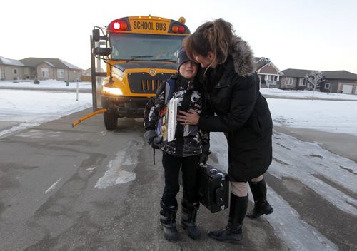 NIVERVILLE, MB - Terri Firlotte, right,  welcomes her 12 year old son Josh, left,  from the school bus at their home. Josh is on the bus over an hour to get home from his french immersion school in the neighbouring town. BORIS MINKEVICH / WINNIPEG FREE PRESS  DEC 2, 2015