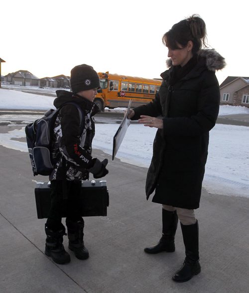 NIVERVILLE, MB - Terri Firlotte, right, welcomes her 12 year old son Josh, left,  from the school bus at their home. Josh is on the bus over an hour to get home from his french immersion school in the neighbouring town. BORIS MINKEVICH / WINNIPEG FREE PRESS  DEC 2, 2015
