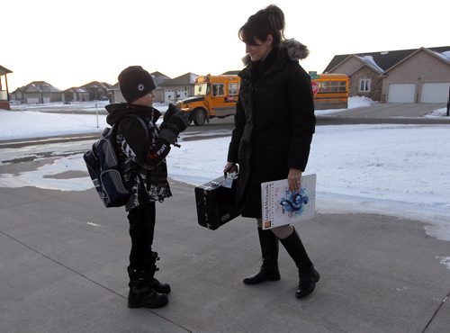 NIVERVILLE, MB - Terri Firlotte, right, welcomes her 12 year old son Josh, left,  from the school bus at their home. Josh is on the bus over an hour to get home from his french immersion school in the neighbouring town. BORIS MINKEVICH / WINNIPEG FREE PRESS  DEC 2, 2015