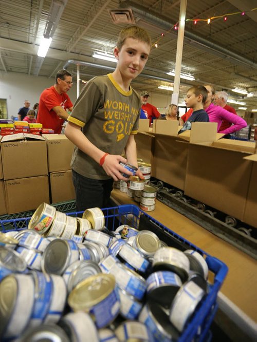 Balmoral School student Jonathan Shipley handles canned meat as Interlake grade 5-7 students from Balmoral Schools Social Justice Group came into Winnipeg on Dec. 3 to pitch in filling food hampers at the Christmas Cheer Board. Groups of school kids are now coming to the Cheer Board every day to help out loading up some of the approximately 19,000 hampers that will be given out this holiday season. Photo by Jason Halstead/Winnipeg Free Press RE: Social Page