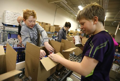 L-R: Balmoral School students Dylan Holod and Connor Smith work as Interlake grade 5-7 students from Balmoral Schools Social Justice Group came into Winnipeg on Dec. 3 to pitch in filling food hampers at the Christmas Cheer Board. Groups of school kids are now coming to the Cheer Board every day to help out loading up some of the approximately 19,000 hampers that will be given out this holiday season. Photo by Jason Halstead/Winnipeg Free Press RE: Social Page