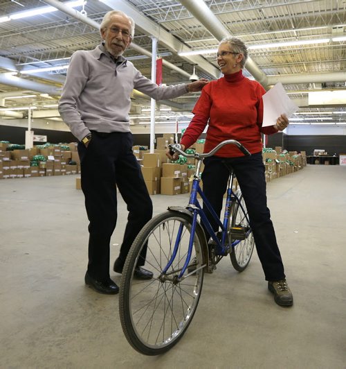 Cheer Board assistant executive director Linda Grayston (with executive director Kai Madsen) puts her vintage bike to use as she does her daily work in the spacious warehouse. Interlake grade 5-7 students from Balmoral Schools Social Justice Group came into Winnipeg on Dec. 3 to pitch in filling food hampers at the Christmas Cheer Board. Groups of school kids are now coming to the Cheer Board every day to help out loading up some of the approximately 19,000 hampers that will be given out this holiday season. Photo by Jason Halstead/Winnipeg Free Press RE: Social Page