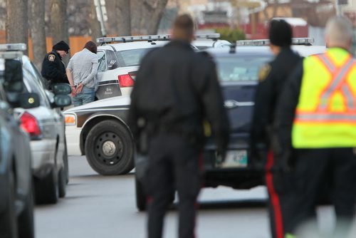 December 5, 2015 - 151205  -  Police detain three people from a home in the 600 block of Adsum Saturday, December 5, 2015. John Woods / Winnipeg Free Press