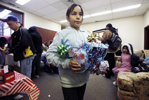 December 8, 2015 - 151208  -  Trisha Traverse heads off with her wrapped gifts at a Christmas popup shop at the Indigenous Family Centre Tuesday, December 8, 2015. Think Shift, an advertising agency based in Winnipeg, in partnership with North End Community Renewal Corp. and the Indigenous Family Centre  has set up a pop-up shop in the citys North End where youth and community members are invited to shop for free gifts for family and friends. John Woods / Winnipeg Free Press