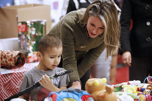 December 8, 2015 - 151208  - Brigitte Burgoyne, a Think Shift employee, helps a boy find some gifts at a Christmas popup shop at the Indigenous Family Centre Tuesday, December 8, 2015. Think Shift, an advertising agency based in Winnipeg, in partnership with North End Community Renewal Corp. and the Indigenous Family Centre  has set up a pop-up shop in the citys North End where youth and community members are invited to shop for free gifts for family and friends. John Woods / Winnipeg Free Press