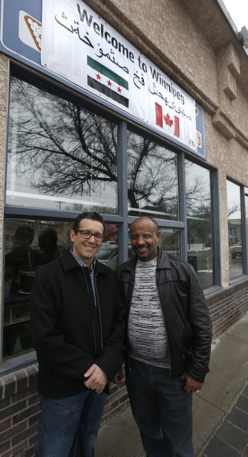 At left, Sal Infantino owner of X-Cues Billiards and Café on Sargent Ave. with the Welcome to Winnipeg sign in Arabic in front of his business along with customer Amare Gebru will be welcoming newcomers to the West End.  Carol Sanders story   Wayne Glowacki / Winnipeg Free Press Dec. 10   2015
