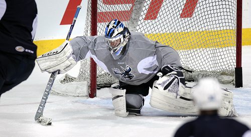 Manitoba Moose netminder Eric Comrie scoops up a loose puck at the Friday morning team workout. See melissa Tait's story. December 12, 2015 - (Phil Hossack / Winnipeg Free Press)