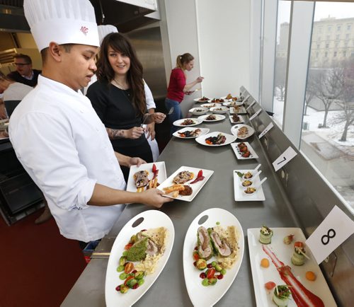 At left,  student Mark Torres speaks to judge Korene McCaig as he places his pork entree on the table to be judged in the 2015 Manitoba Pork Competition. The event held in the Red River College - Paterson GlobalFoods Institute on Friday. In back Judge Laurel Lyons with Manitoba Pork samples a dish.    Nick Martin story Wayne Glowacki / Winnipeg Free Press Dec. 11   2015
