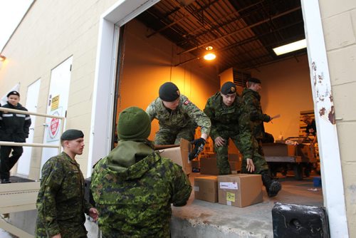 Winnipeg Army Reservists load up boxes of food, gifts and turkeys from the Christmas Cheer Board loading ramps that they will deliver to families in need across the city as part of the annual Exercise Parcel Push Campaign Saturday morning.   Standup photo Dec 12, 2015 Ruth Bonneville / Winnipeg Free Press