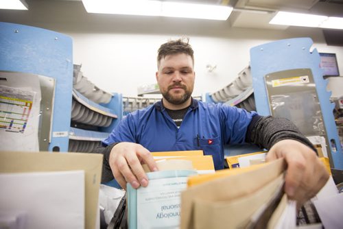 Letter carrier Ryan Pearson sorts letters before going out on his route on the busiest day of the year in Winnipeg on Monday, Dec. 14, 2015.  (Mikaela MacKenzie/Winnipeg Free Press)
