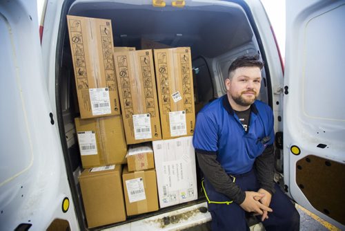 Letter carrier Ryan Pearson takes a moment at his packed truck before going out on his route on the busiest day of the year in Winnipeg on Monday, Dec. 14, 2015.  (Mikaela MacKenzie/Winnipeg Free Press)