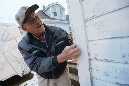 December 15, 2015 - 151215  -  Rodney Pearson, 76, checks the condition of his exterior house paint on Redwood Avenue Tuesday, December 15, 2015. Pearson and his wife Doris, who have been married for 53 years, have lived in the house for 45 years and recently received a Winnipeg Neigbourhood Liveability Bylaw Order from the city to paint the outside of their home by this spring or face a $1000 fine and jail time. John Woods / Winnipeg Free Press