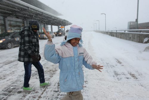 Eight-year-old Gianna Dinzey from Trinadad and her brother Joshua -11yrs, are elated as they experience snow for the first time in their lives after arriving at the Wpg airport Wednesday with their dad to visit family here in Wpg for Christmas.   Standup photo  Dec 16, 2015 Ruth Bonneville / Winnipeg Free Press