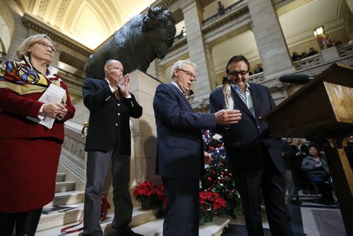At the Manitoba Legislature in Winnipeg today, Thursday, December 17, 2015 provincial minister Eric Robinson passes an eagle feather to Manitoba Premier Greg Selinger as Carolyn Bennett, Minister of Indigenous and Northern Affairs and Manitoba Minister Drew Caldwell look on during an announcement of an intergovernmental partnership that will benefit the First Nation by building a 24 km road from the Shoal Lake No.40 First Nation community to the Trans Canada Highway.   THE CANADIAN PRESS/John Woods