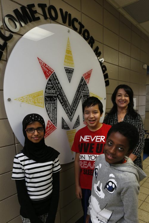 Victor Mager School students from left, Laiba, Logan and Peniel with their principal Karen Magnusson by the language wheel with welcome written in every language spoken at the school. Nick Martin story.Wayne Glowacki / Winnipeg Free Press Dec. 17 2015