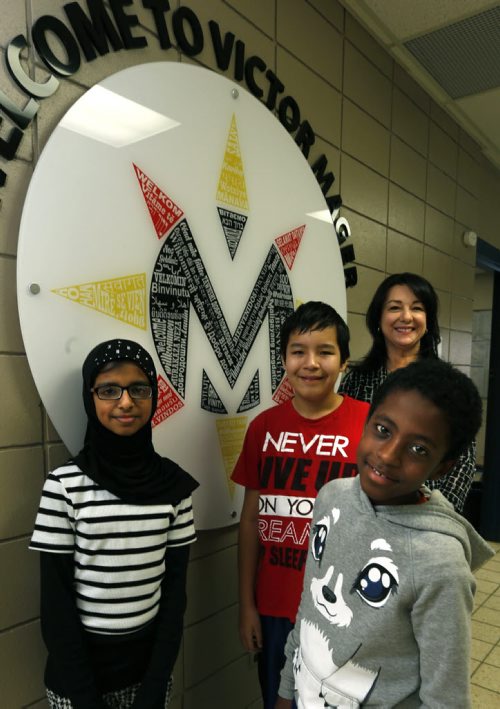 Victor Mager School students from left, Laiba, Logan and Peniel with their principal Karen Magnusson by the language wheel with welcome written in every language spoken at the school. Nick Martin story.Wayne Glowacki / Winnipeg Free Press Dec. 17 2015