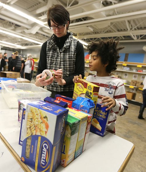 Alison Nolet and her son Kai Toney, 8, volunteer at Winnipeg Harvest as part of Family Night on Dec. 17, 2015. Photo by Jason Halstead/Winnipeg Free Press RE: Social Page for Dec. 19, 2015