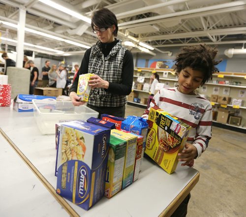 Alison Nolet and her son Kai Toney, 8, volunteer at Winnipeg Harvest as part of Family Night on Dec. 17, 2015. Photo by Jason Halstead/Winnipeg Free Press RE: Social Page for Dec. 19, 2015