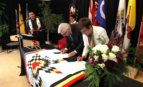Dr. David Barnard, President of U of M and Dr. Annette Trimbee President of U of W, sign the  Indigenous Education Blueprints at a formal event Friday held at the U of M's Migizii Agamik  Bald Eagle Lodge. Host, Wabanakwut (Wab) Kinew looks on in far left.  See Nick Martin story.  Dec 18, 2015 Ruth Bonneville / Winnipeg Free Press