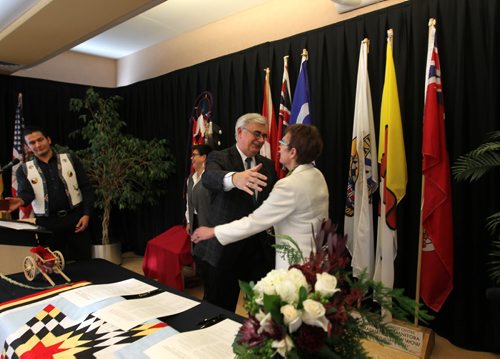 Dr. David Barnard, President of U of M and Dr. Annette Trimbee President of U of W, embrace after signing the Indigenous Education Blueprints at a formal event Friday held at the U of M's Migizii Agamik  Bald Eagle Lodge. Host, Wabanakwut (Wab) Kinew looks on in far left.  See Nick Martin story.  Dec 18, 2015 Ruth Bonneville / Winnipeg Free Press