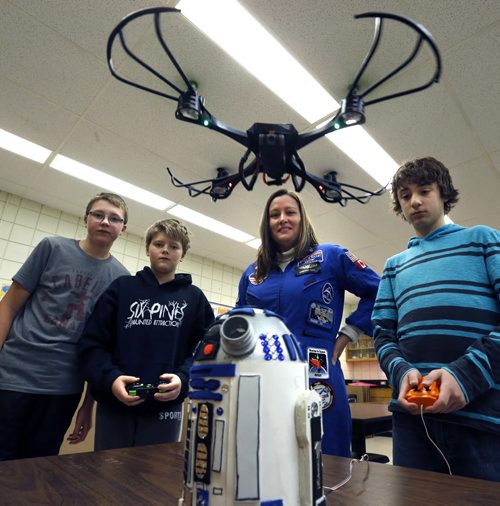 Maria Nickel, Space Club Mentor (centre)  with her Ecole Stonewall Centennial School Space Club members from left, Connor Wolfe, Thomas Thevenot operates the flying drone as Sean Mullin controls the hand made remote controlled R2D2 robot in their classroom.  The Space Club members had a chance to showcase to the media the technological skills they have learnt. The event was in honour of the release of the new Star Wars: The Force Awakens movie. In the afternoon the class had the opportunity to watch  The Star Wars: Episode VI Return of the Jedi. Wayne Glowacki / Winnipeg Free Press Dec. 18  2015