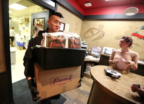 Delivery driver Steven Tran prepares to take out a big order at 4 Seasons Chinese Food at Southdale Centre on Dec. 18, 2015. The Chinese take-out and delivery restaurant has been in operation for almost 30 years and is extremely busy this time of year. Customers usually start placing their orders for Christmas and New Years Eve in August or September. Photo by Jason Halstead/Winnipeg Free Press RE: Dave Sanderson story