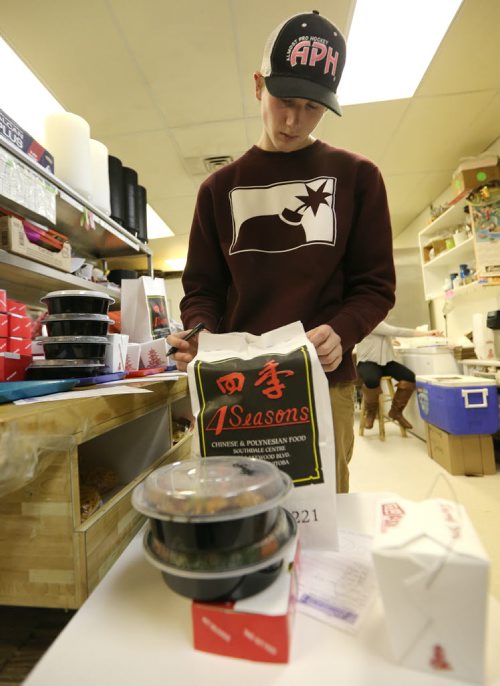 Packer Bryce Nash works at 4 Seasons Chinese Food at Southdale Centre on Dec. 18, 2015. The Chinese take-out and delivery restaurant has been in operation for almost 30 years and is extremely busy this time of year. Customers usually start placing their orders for Christmas and New Years Eve in August or September. Photo by Jason Halstead/Winnipeg Free Press RE: Dave Sanderson story