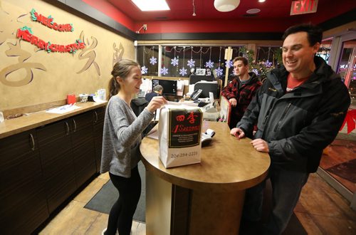 Skye Rickner hands food to a customer at 4 Seasons Chinese Food at Southdale Centre on Dec. 18, 2015. The Chinese take-out and delivery restaurant has been in operation for almost 30 years and is extremely busy this time of year. Customers usually start placing their orders for Christmas and New Years Eve in August or September. Photo by Jason Halstead/Winnipeg Free Press RE: Dave Sanderson story