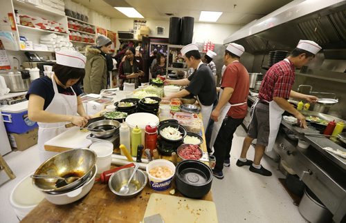 Owner Cathy Rickner (middle, rear) checks on the busy kitchen at 4 Seasons Chinese Food at Southdale Centre on Dec. 18, 2015. The Chinese take-out and delivery restaurant has been in operation for almost 30 years and is extremely busy this time of year. Customers usually start placing their orders for Christmas and New Years Eve in August or September. Photo by Jason Halstead/Winnipeg Free Press RE: Dave Sanderson story