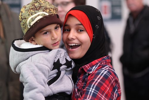 Twelve year old Wafaa Abukhousa who was a refugee from Syria herself 6 years ago, holds Jawad Daas -2yrs  in her arms after he arrives with his  family from Syria at the airport in Winnipeg Saturday.  Wafaa and her  older sister Doaa are acting as translators for the family as they settle in Altona. See MA story.  Dec 19, 2015 Ruth Bonneville / Winnipeg Free Press