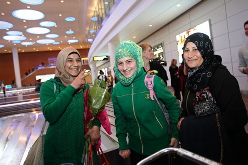 One of the teenage girls of the  Daas family from Syria gives the peace sign as she smiles with her sister and mom while collecting luggage after arriving into Winnipeg Saturday.  They are  one of the first Syrian families to arrive into Winnipeg and  settle in Altona. See MA story.  Dec 19, 2015 Ruth Bonneville / Winnipeg Free Press