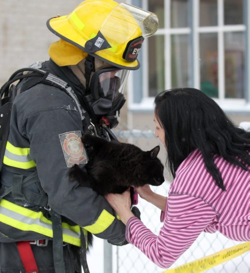 Tenant Ellie LaRosa  is reunited with her cat Oreo after a firefighter rescued the animal from a apartment fire at 686 Toronto Ave Monday morningPolice have closed Toronto from Sargent Ave to Wellington-Breaking News-Dec 21, 2015 (JOE BRYKSA / WINNIPEG FREE PRESS)