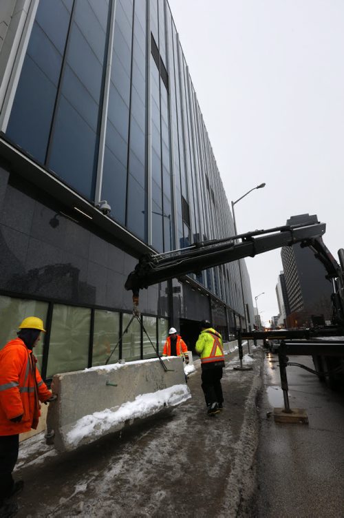 Crews install concrete security dividers by the the new police HQ along Smith St. Monday. Bart Kives story. Wayne Glowacki / Winnipeg Free Press Dec. 21  2015