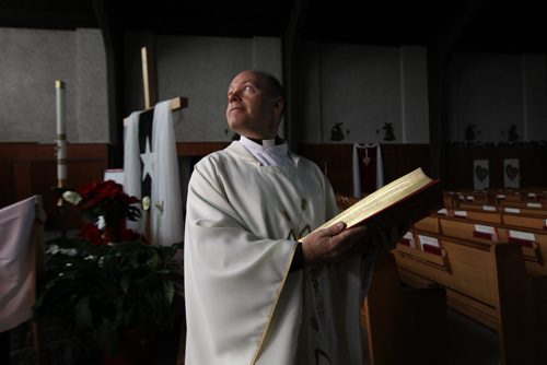 Christmas Front: Parish - St. Paul the Apostle, Father Eric Giddens  Father Giddens prepares for his Christmas message to his parishoners on making room in their lives for the new Syrian family the church is sponsoring that will arrive in early in new year. See Paul Wiecek's story Dec 22, 2015 Ruth Bonneville / Winnipeg Free Press