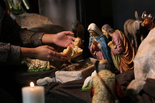 Christmas Front: Parish - St. Paul the Apostle, Father Eric Giddens   Father Giddens meets with parish trustee, Frank Barnes,  discussing sponsoring the new Syrian family that will  arrive in early in new year. Placing the figurine of baby Jesus in the nativity scene in front of the church.  See Paul Wiecek's story  Dec 22, 2015 Ruth Bonneville / Winnipeg Free Press